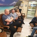 grupa osób siedzących w komorze normobarycznej w trakcie tlenoterapii